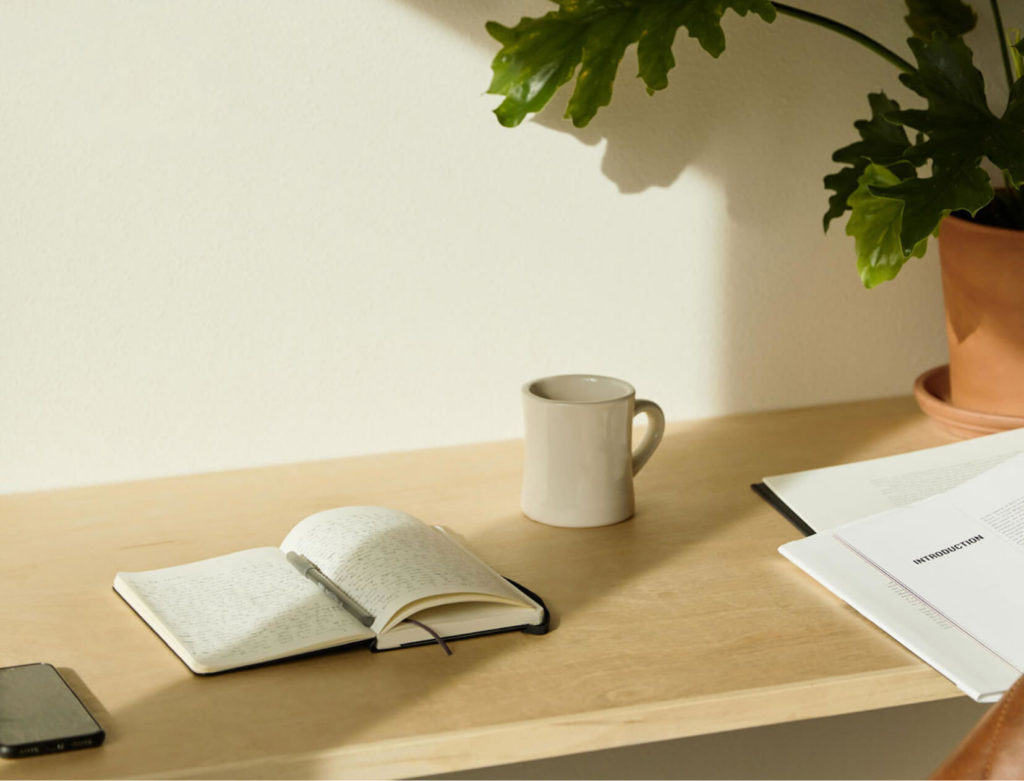 Open notebook and mug on a desk